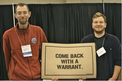 Members of the Whole Life Buying Club based in Louisville, Kentucky defied a quarantine order issued by the state health department in May; club co-administrator John Moody and Caine Halbrook received a doormat at an event in Dallas in honor of the club’s successful act of group defiance. Photo Credit: Cheeseslave